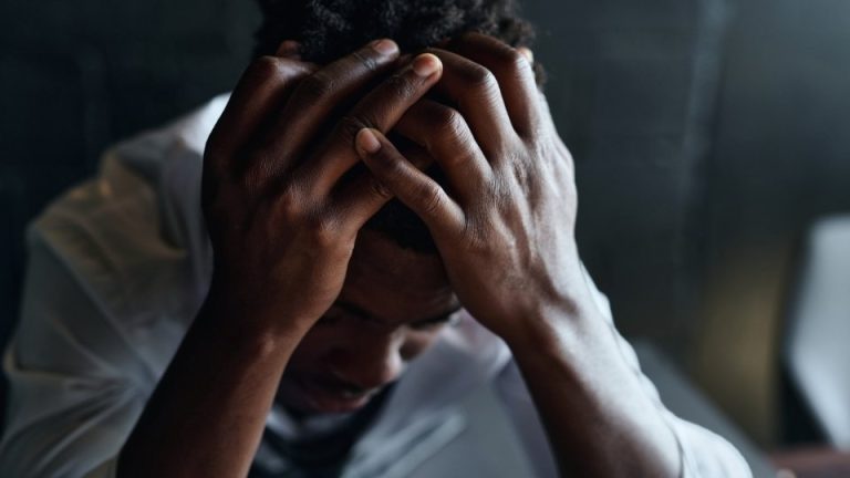 Does Drinking Alcohol Cause Anxiety hero image of a man feeling down.