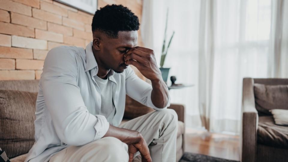 Long-Term Effects of Alcohol on the Body worry a man sitting on the couch.